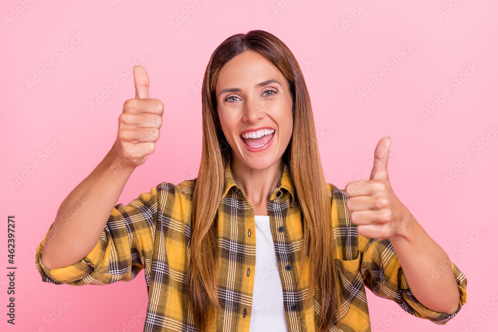 Portrait of positive excited lady show two thumbs up beaming smile isolated on pink color background Portrait of positive excited lady show two thumbs up beaming smile isolated on pink color background
