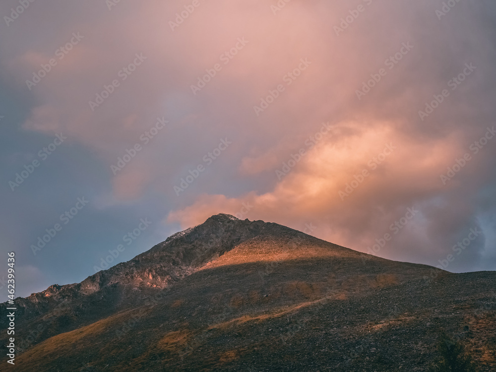 Mountains at dawn. Atmospheric landscape with silhouettes of mountains on background of pink dawn sky. Colorful nature scenery with sunset or sunrise. Sundown in faded tones.