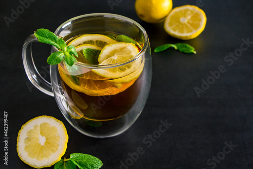 Herbal tea with lemon and mint on dark background. Delicious drink for relaxation and refreshment