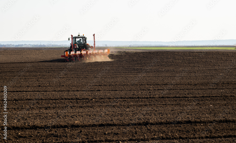 Fototapeta premium Farmer with tractor seeding