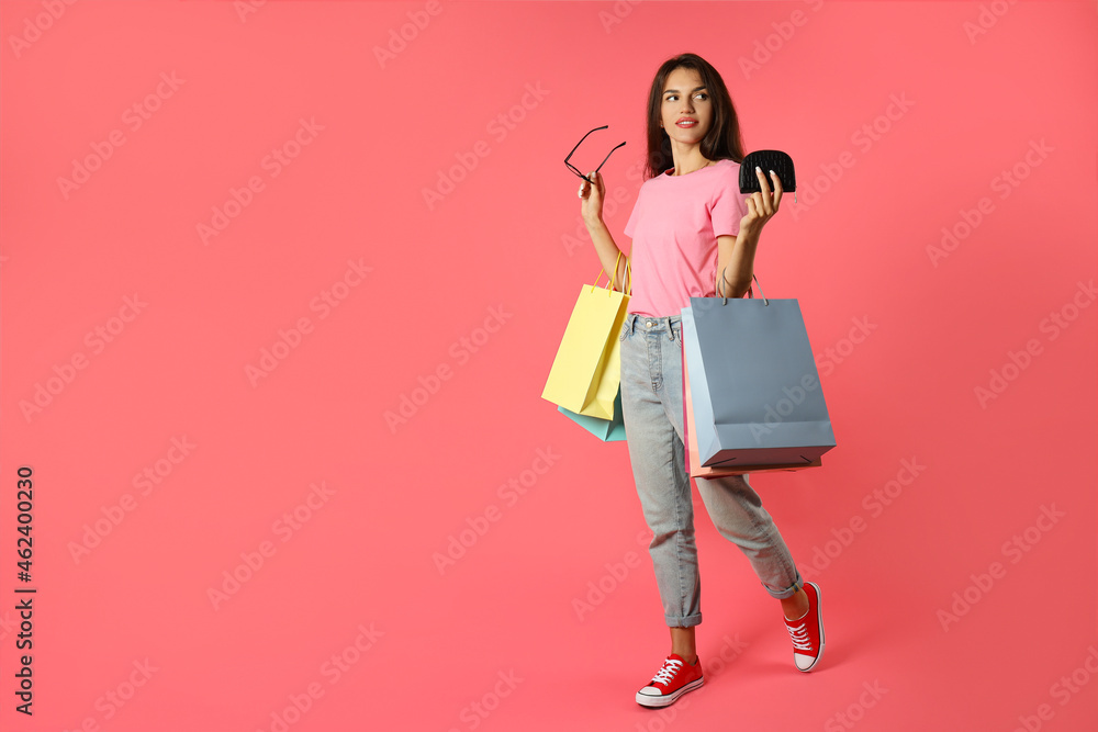 Attractive girl with multicolored paper bags on pink background Attractive girl with multicolored paper bags on pink background