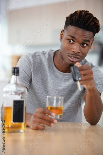 man with car key and alcoholic beverage in bar
