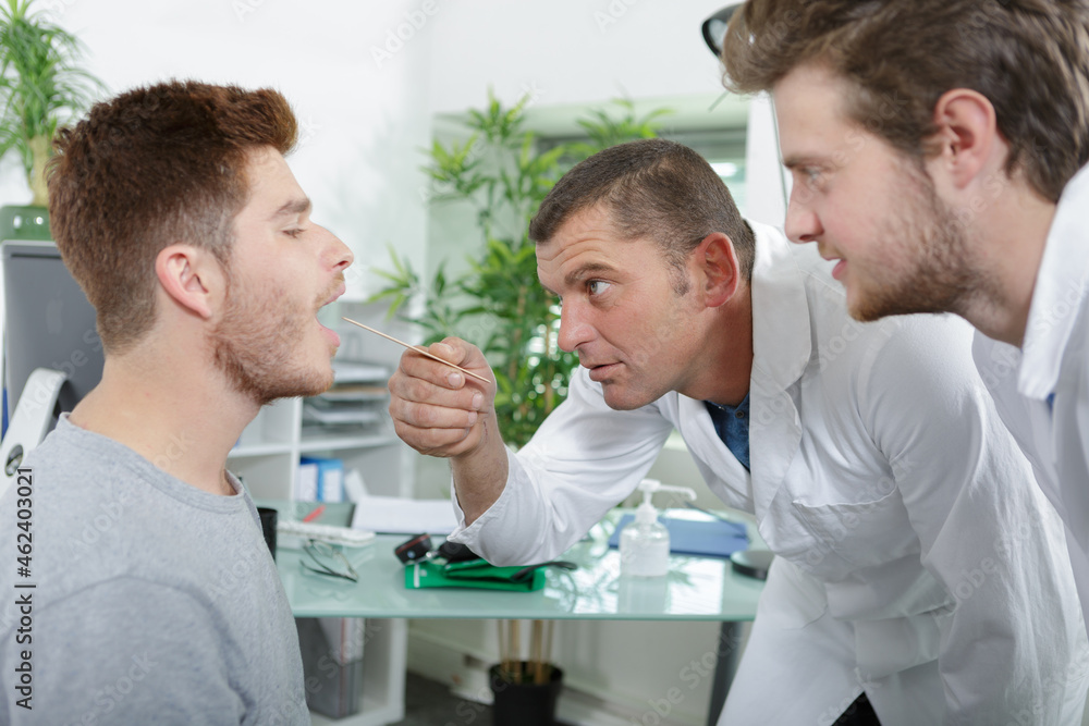 doctor checking a patient throat doctor checking a patient throat