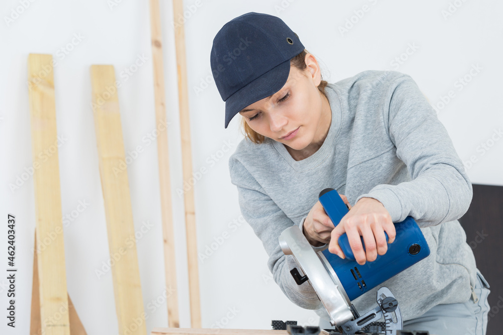 female carpenter using circular saw