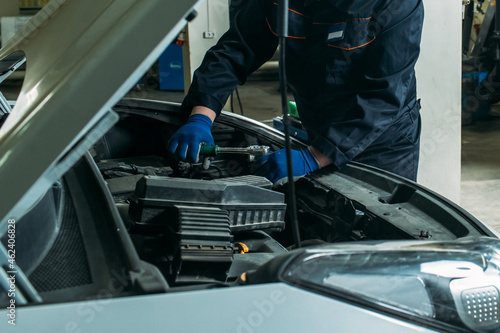 car service, an employee replaces and tests the car battery
