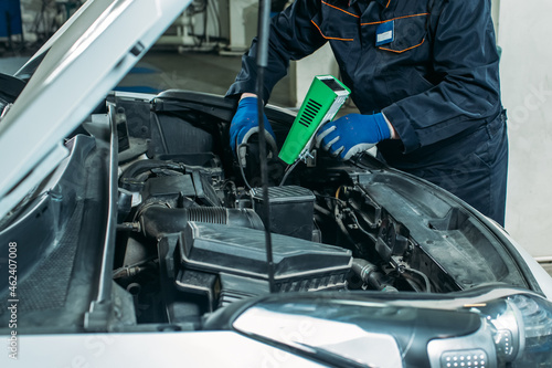 car service, an employee replaces and tests the car battery