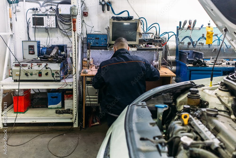 car service, an employee repairs and tests car parts car service, an employee repairs and tests car parts