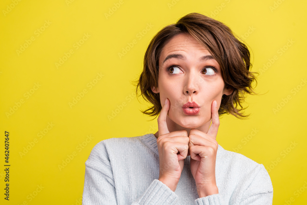 Photo of excited lady finger cheek look empty space open mouth wear blue sweater isolated yellow color background Photo of excited lady finger cheek look empty space open mouth wear blue sweater isolated yellow color background