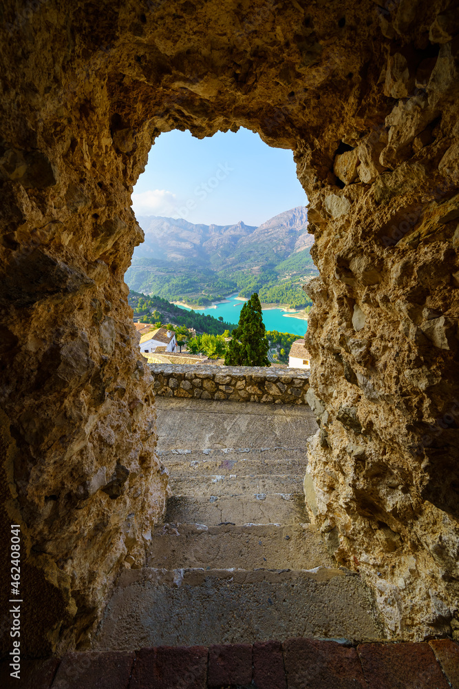 Rocky cave exit that overlooks a viewpoint to the town in the mountains. Guadalest Alicante.