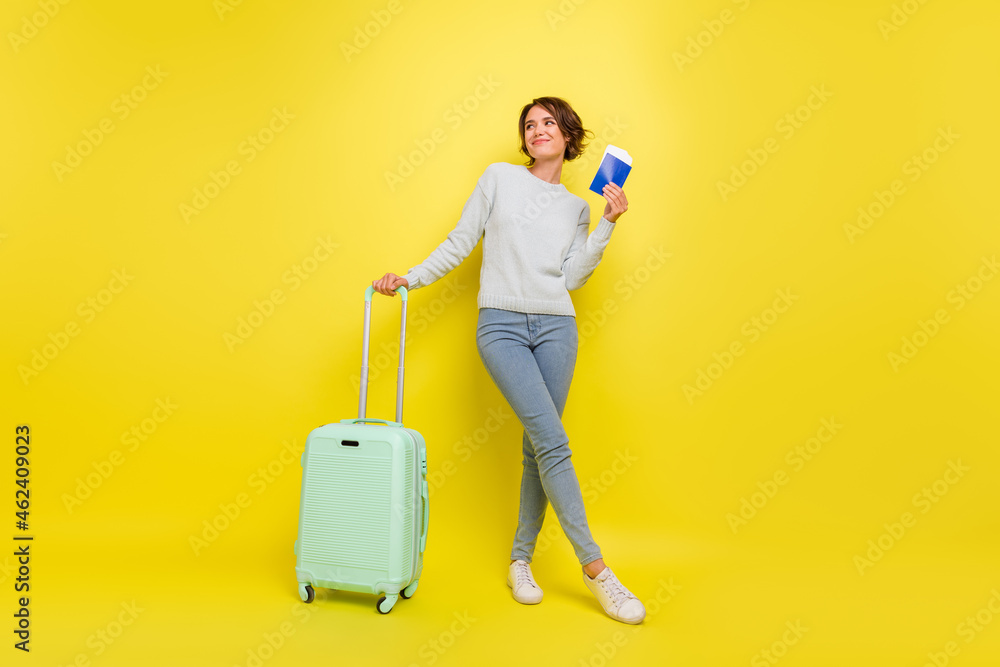Photo of dreamy lady hold passport case look empty space wear blue sweater jeans shoes isolated yellow color background Photo of dreamy lady hold passport case look empty space wear blue sweater jeans shoes isolated yellow color background