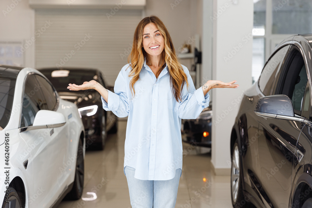 uncertain fun woman customer female buyer client wears blue shirt chooses auto between two cars wants buy new automobile in car showroom vehicle salon dealership store motor show indoor Sales concept uncertain fun woman customer female buyer client wears blue shirt chooses auto between two cars wants buy new automobile in car showroom vehicle salon dealership store motor show indoor Sales concept
