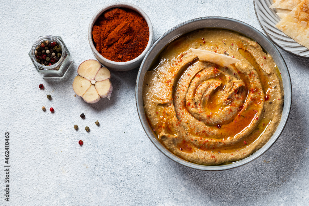 Traditional arabian eggplant dip baba ganoush with herbs and smoked paprika on light background. Eggplant hummus. Babaganush or eggplant caviar. Baked eggplant. Turkish eggplant dip Traditional arabian eggplant dip baba ganoush with herbs and smoked paprika on light background. Eggplant hummus. Babaganush or eggplant caviar. Baked eggplant. Turkish eggplant dip