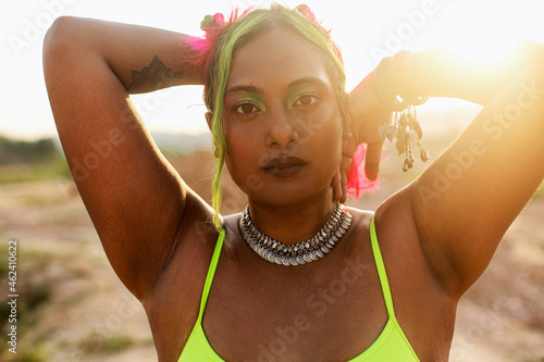 Photography portrait of dark skinned Indian woman in Malaysia, smiling and dancing in a barr