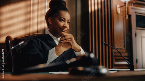 Photography Cinematic Court of Law Trial: Humane Portrait of Impartial Smiling Female Judge Listening Happily to Jury's Verdict