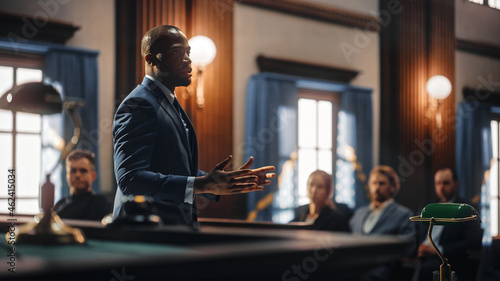 Court of Justice and Law Trial: Male Public Defender Presenting Case, Making Passionate Speech to Judge, Jury. African American Attorney Lawyer Protecting Client's Innocents with Supporting Argument.