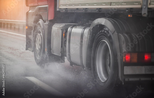 Truck chassis and wheels on a wet road in rainy weather, close-up. Safety concept and tire grip on wet roads, braking distances under emergency braking