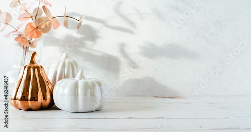 Fototapeta Naklejka Na Ścianę i Meble -  Details of Still life, pumpkins, candle, brunch with leaves on white table background, home decor in a cozy house. Autumn weekend concept. Fallen leaves and home decoration
