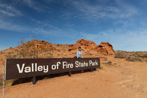Smiling girl standing at Valley of Fire State Park sign