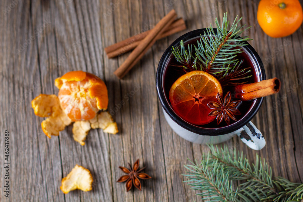 Traditional tasty mulled wine hot drink with mandarin apple spices and christmas tree in white cup Traditional tasty mulled wine hot drink with mandarin apple spices and christmas tree in white cup