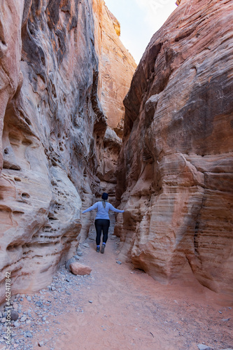 Girl walking into Kaolin Wash slot canyon in Valley of Fire State Park, Nevada, USA 