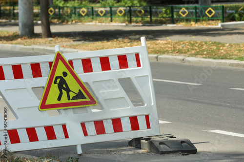 Barricade with road construction sign on city street. Repair works