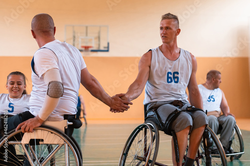 a team of war veterans in wheelchairs playing basketball, celebrating points won in a game. High five concept