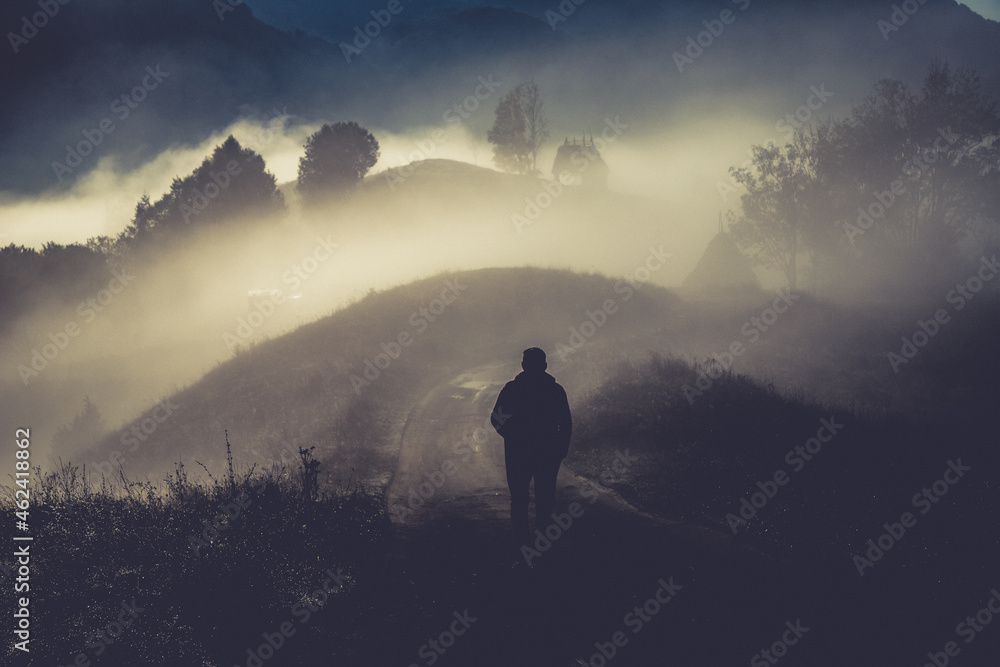 man walking in a foggy autumn landscape - obrazy, fototapety, plakaty 
