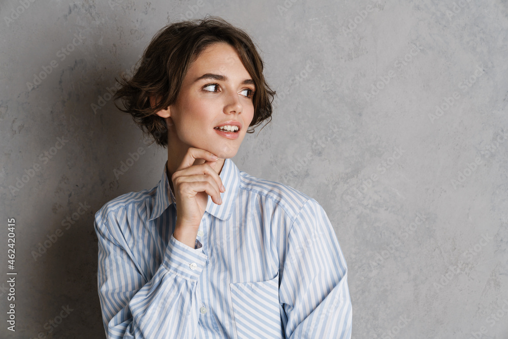 Young brunette woman wearing shirt posing and looking aside Young brunette woman wearing shirt posing and looking aside