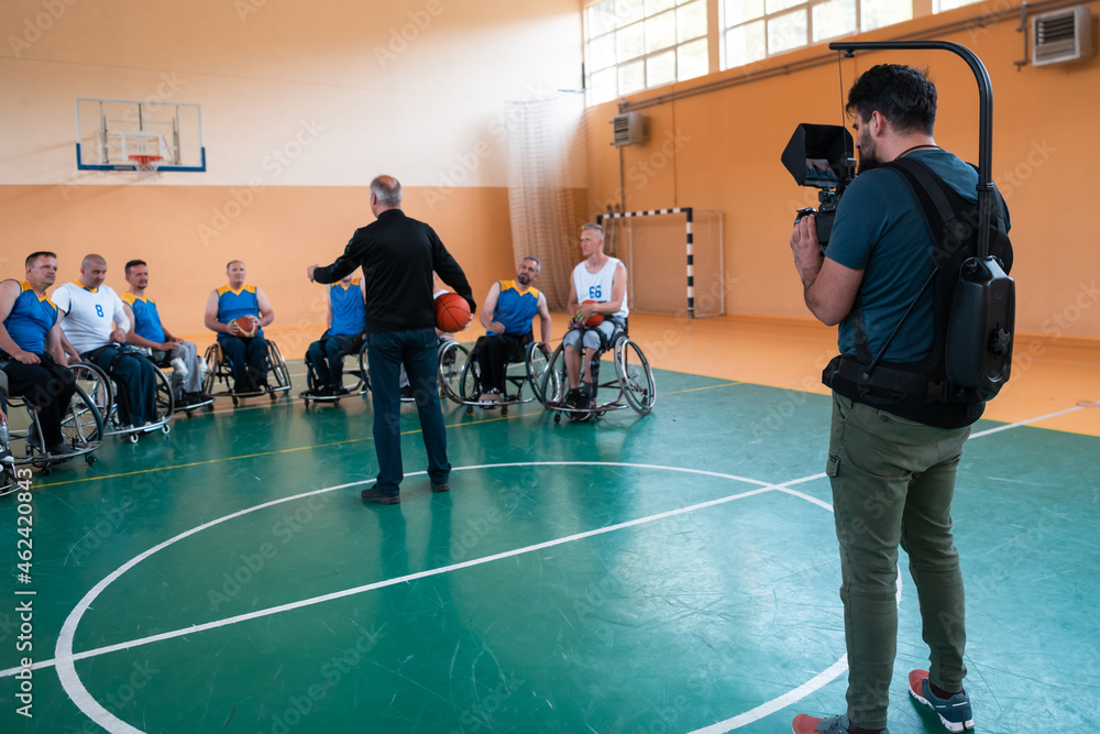 a cameraman with professional equipment records a match of the national team in a wheelchair playing a match in the arena a cameraman with professional equipment records a match of the national team in a wheelchair playing a match in the arena