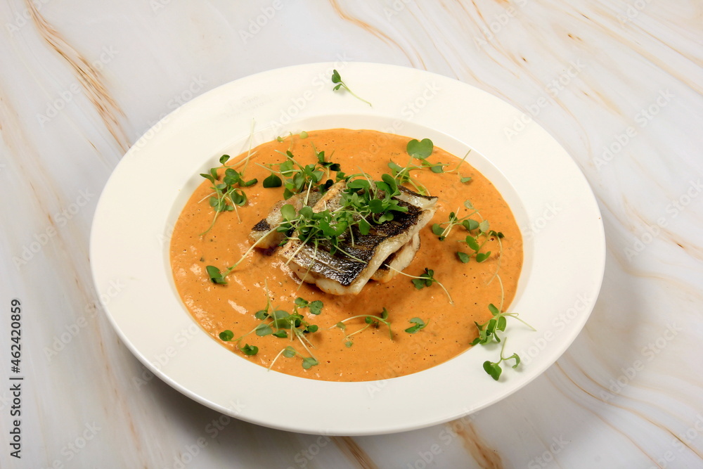 fried sea bass fillet on a vegetable sauce decorated with sprouts. Fried sea fish fried sea bass fillet on a vegetable sauce decorated with sprouts. Fried sea fish