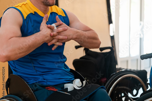 a disabled basketball player puts on a corset and bandages on his arms and fingers in preparation for a game in the arena © .shock