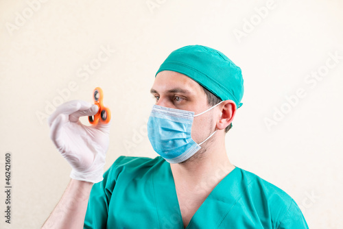 A doctor in a mask and gloves, with a spinner in his hands.