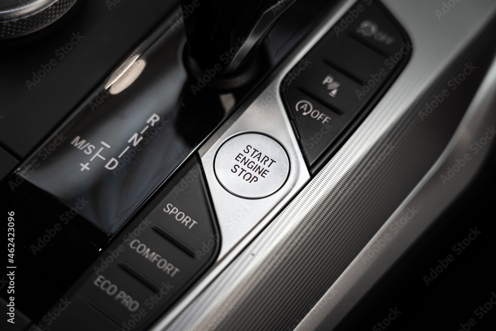 Obraz premium An engine start-stop button of modern luxury sport car. Transportation technology object photo. Close-up and selective focus.