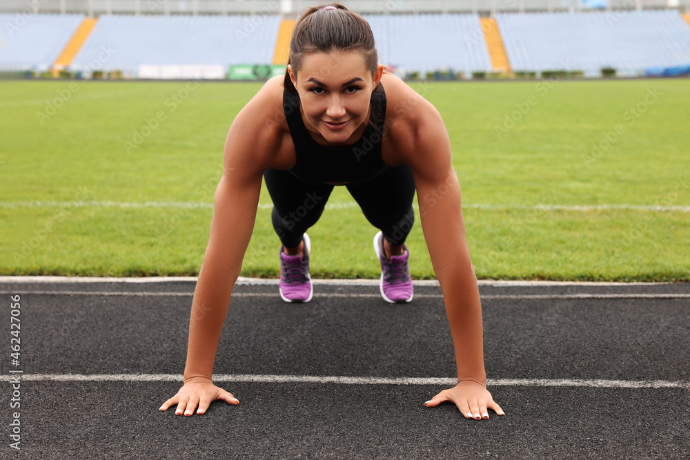 Young woman doing high plank exercise at stadium Young woman doing high plank exercise at stadium