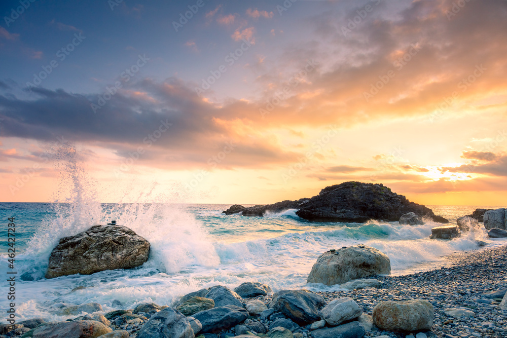 Sea waves break on big stone with beautiful white splashes, sunrise time with beautiful sky