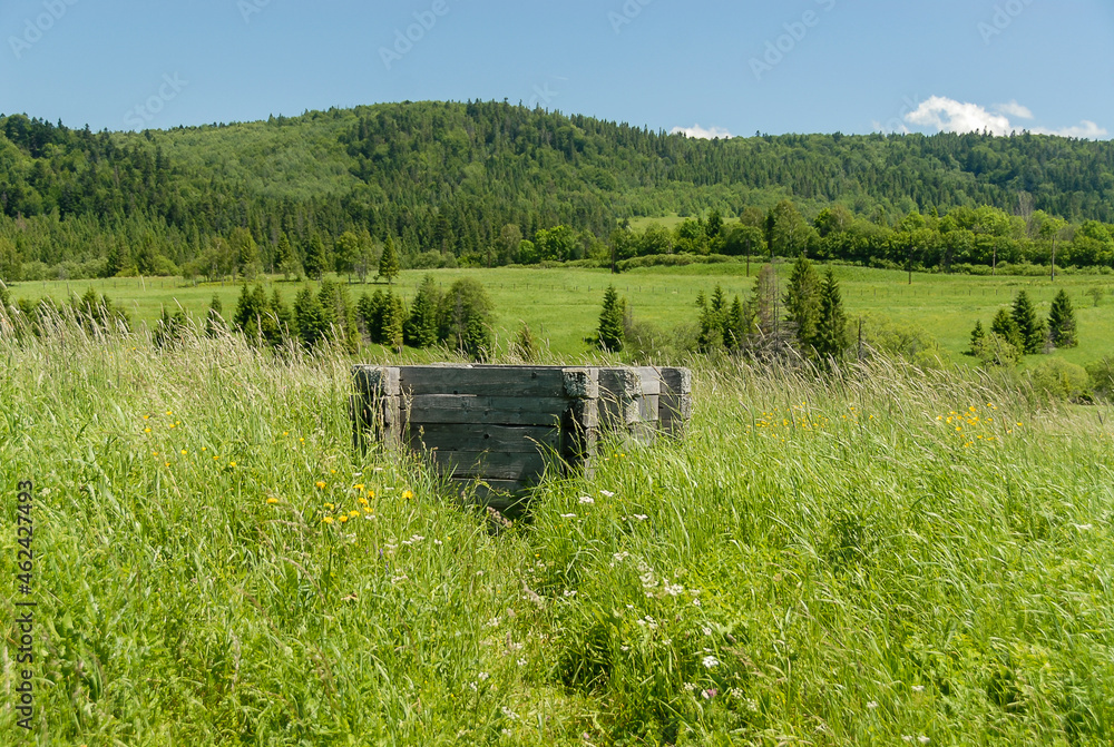 A wooden well among fields and meadows, Bieszczady Mountains, Poland