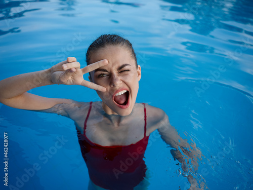 cheerful woman in a swimsuit in the pool emotions relaxation gesture hands