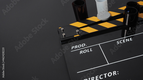 35mm color print film and Clapper board or movie slate on black background. It use in movie and video production industry.