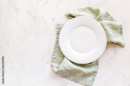 Empty plate on napkin - table setting for dinner. Overhead view