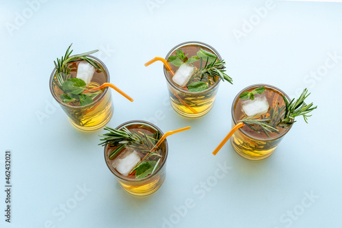 Fresh summer cocktail with cold tea and rosemary in glasses