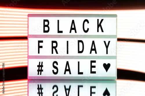 Black friday sale written on information light boxing sign on bright neon background.