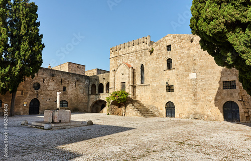 Argyrokastrou - Square of Jewish Martyrs in the old town of Rhodes, Dodecanese, Greece; detail with stairs, tree and sea horse fountain; Medieval buildings within the walls of the old part of Rhodes