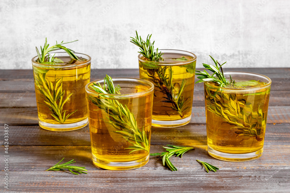 Fefreshing drink of cold tea and rosemary herbs in glasses Fefreshing drink of cold tea and rosemary herbs in glasses