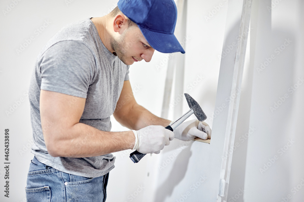 Young adult man painting and fixing on a DIY budget renovation of his new home apartment. Young adult man painting and fixing on a DIY budget renovation of his new home apartment.