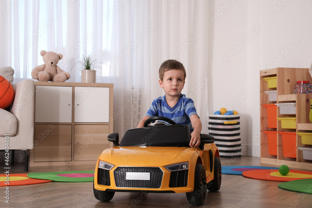 Little child playing with toy car in room - obrazy, fototapety, plakaty 