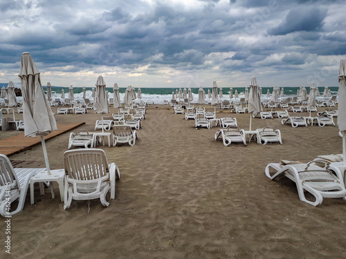 Empty beach chairs with umbrella on a cloudy day in Pomorie, Burgas Bay, Bulgaria. © Lilli Bähr