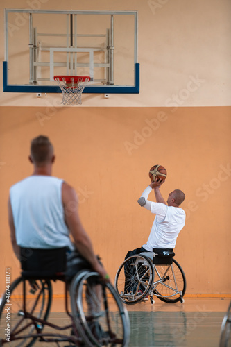 Disabled War veterans mixed race and age basketball teams in wheelchairs playing a training match in a sports gym hall. Handicapped people rehabilitation and inclusion concept © .shock