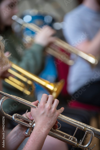 a small jazz band showing close ups of hands on brass instruments