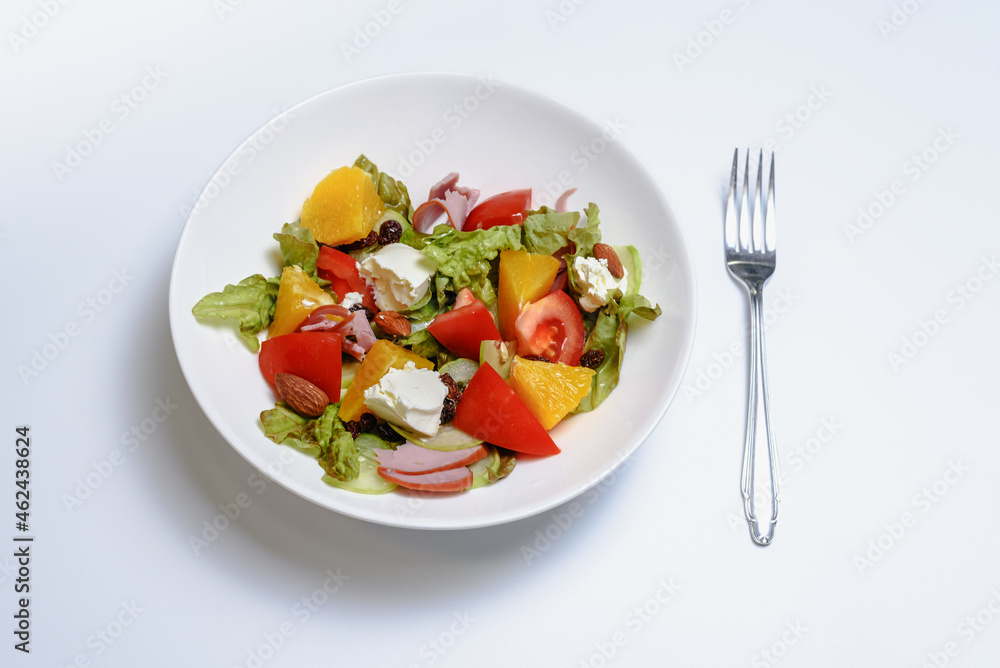 A bowl of fresh fruit and cheese salad on white background