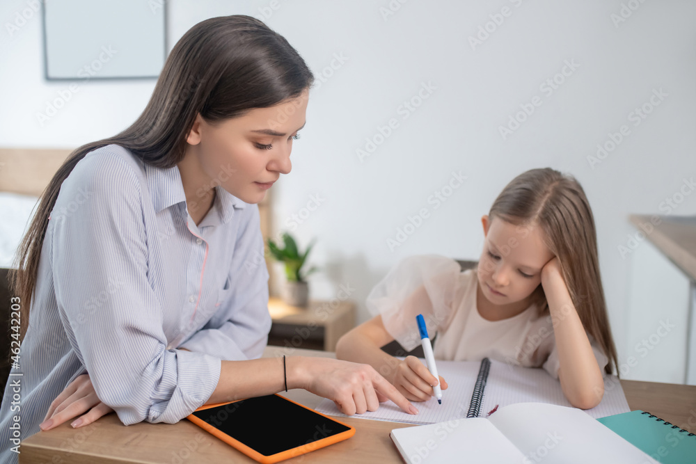 A long-haired girl studying at home and looking involved A long-haired girl studying at home and looking involved